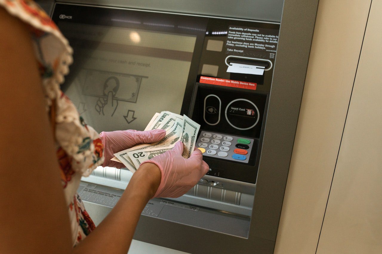 A woman receiving cash from an ATM.